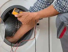 Washing machine repair technician testing a front-load washer with diagnostic tools in Birmingham, AL